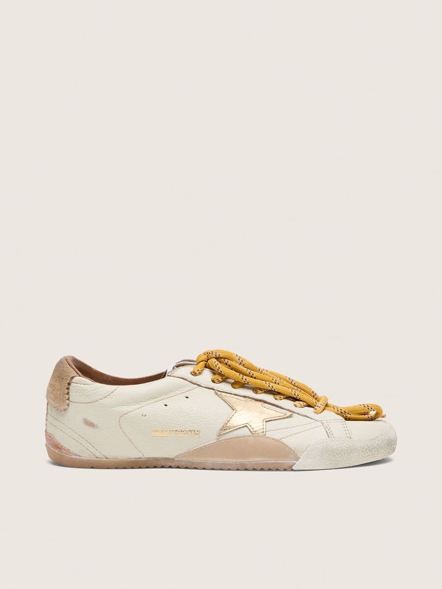 tênis masculino true-star em couro napa branco com estrela de couro dourada e detalhe em camurça bege no calcanhar.