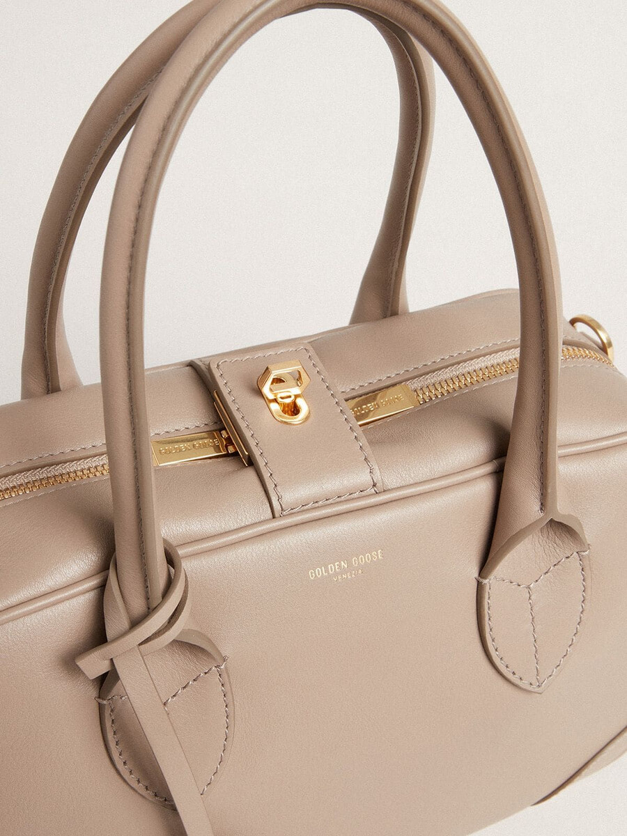 bolsa vita em couro taupe com detalhes dourados.